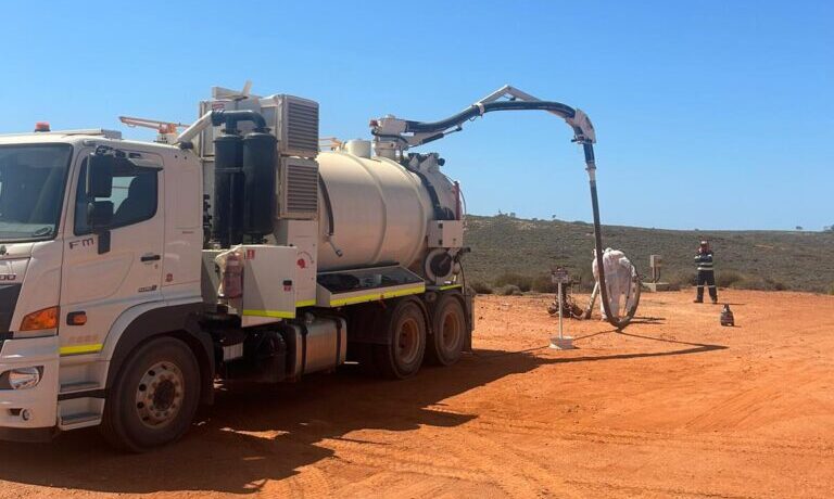 Vacuum Excavation for Mining Sites in WA iVac WA vacuum excavation truck operating on a remote red-dirt mine site in WA, with crew on the ground.